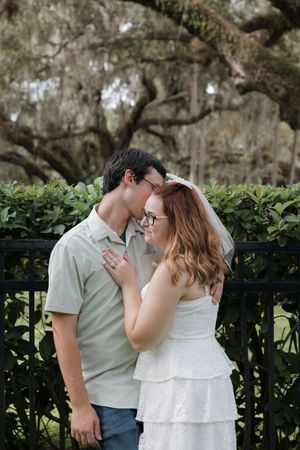 A tender moment shared between a couple by a garden fence.