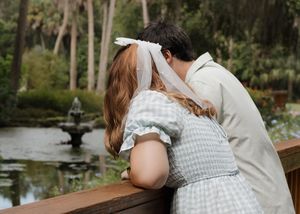 A couple shares a romantic moment overlooking a peaceful pond.