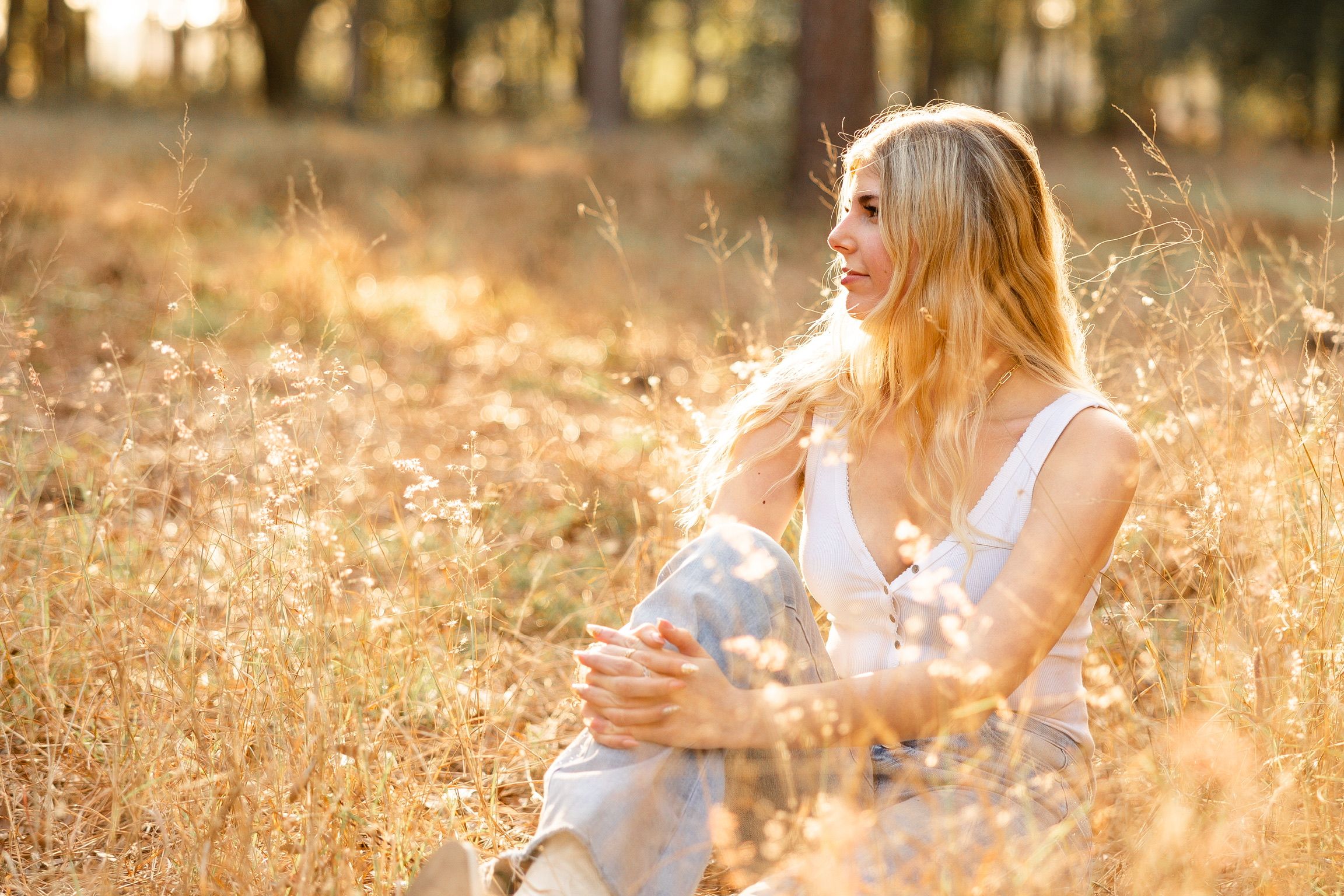 A person in a white dress walks through a golden field at sunset creating a dreamy summer atmosphere.