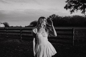 Ethereal black and white portrait session in a countryside setting with dramatic lighting.