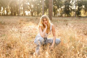 Sun-drenched field with tall grass and trees creating a warm, golden afternoon atmosphere.