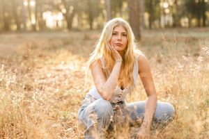 Golden hour portrait session in a sun-drenched field with tall grass.