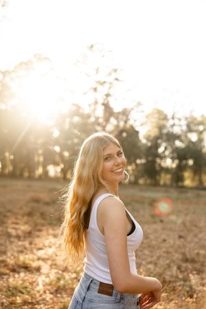 Warm sunset light illuminates a pastoral scene with casual summer attire.