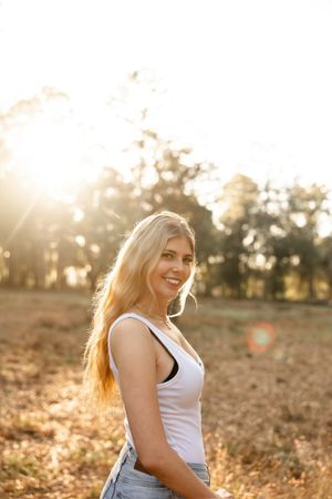 Golden sunset portrait session in a rustic field with warm backlighting.
