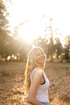 Warm sunlight streams through trees creating a golden glow in a rural setting.