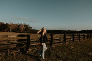 Panoramic view of a rustic wooden fence stretching across a rural field at sunset.