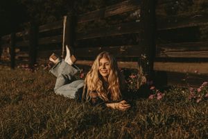 Artistic outdoor portrait session along a weathered wooden fence during golden hour.
