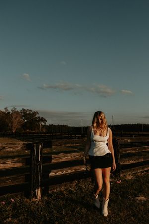 Rustic wooden fence stretches across a rural landscape during golden hour.