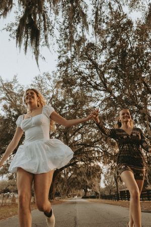 A series of artistic dance poses captured in warm sunlight beneath Spanish moss-draped trees on a rural path.