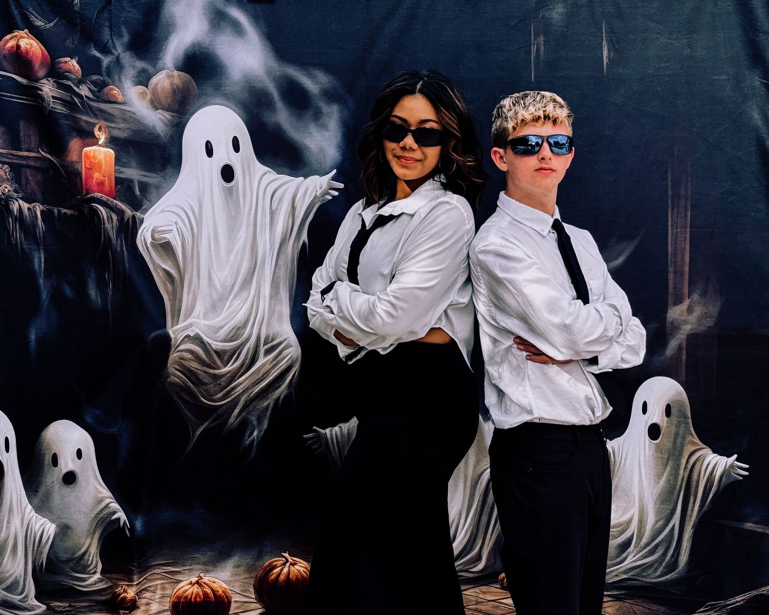 A spooky Halloween scene with ghost decorations, candles, and a red dress against a dark atmospheric background.