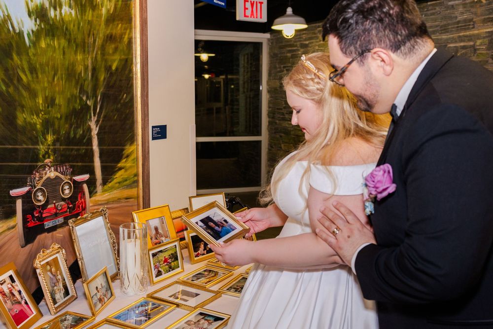 Wedding reception guests dancing and celebrating on a wooden floor under warm lighting in an indoor venue.