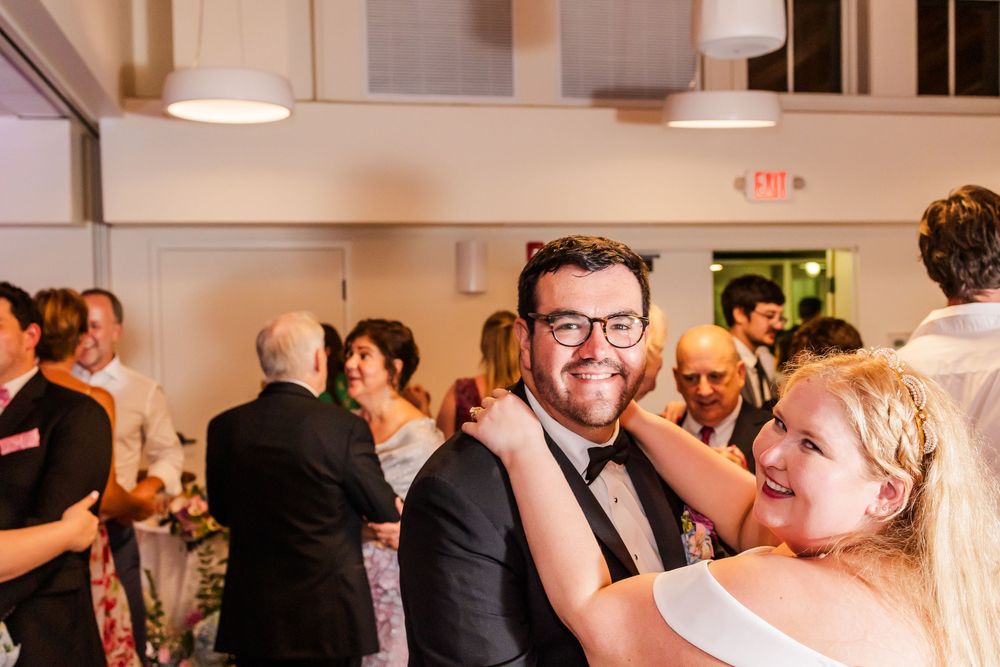 Guests celebrate at an indoor wedding reception with warm lighting and festive atmosphere.