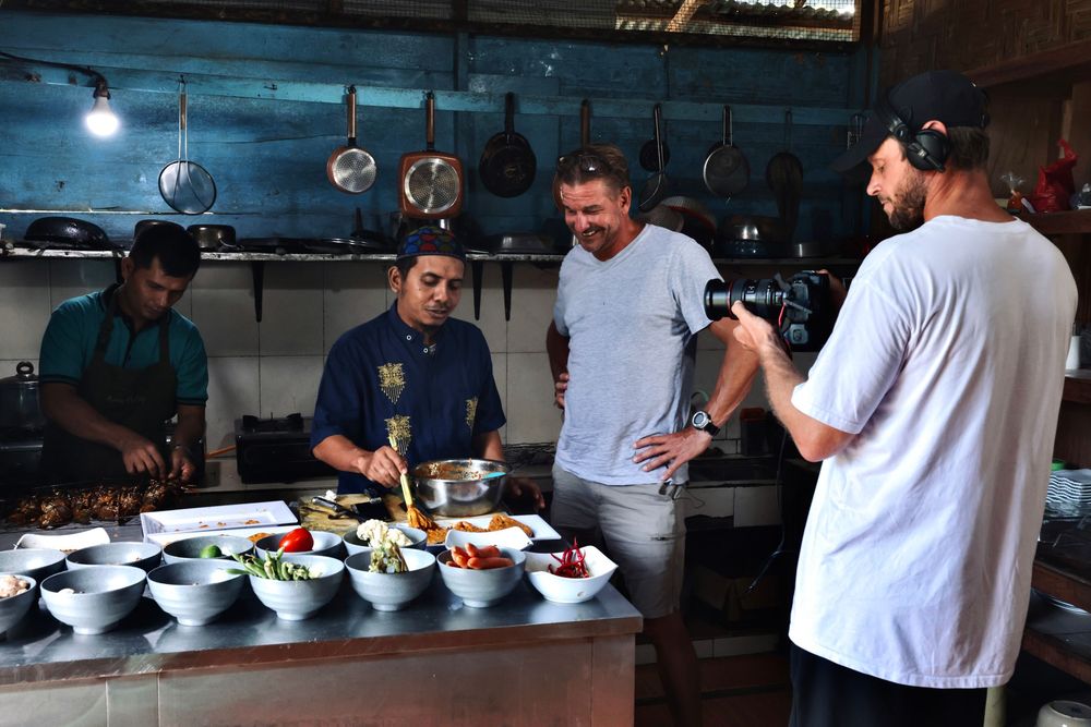 People dining at a casual restaurant counter with white plates of food.