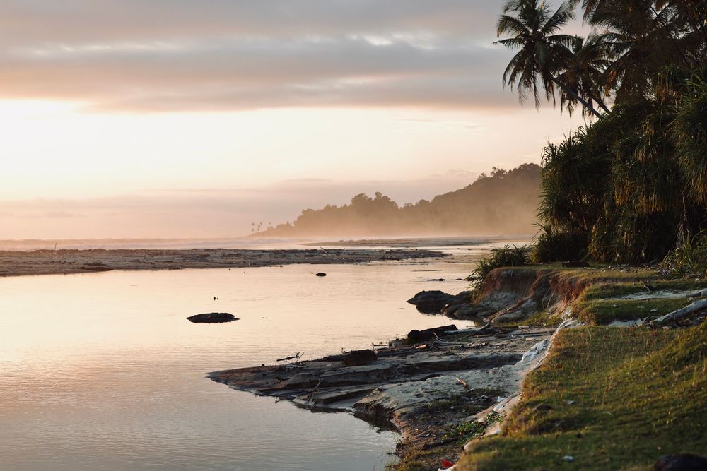 Panoramic coastal landscape with rocky shoreline at sunset.