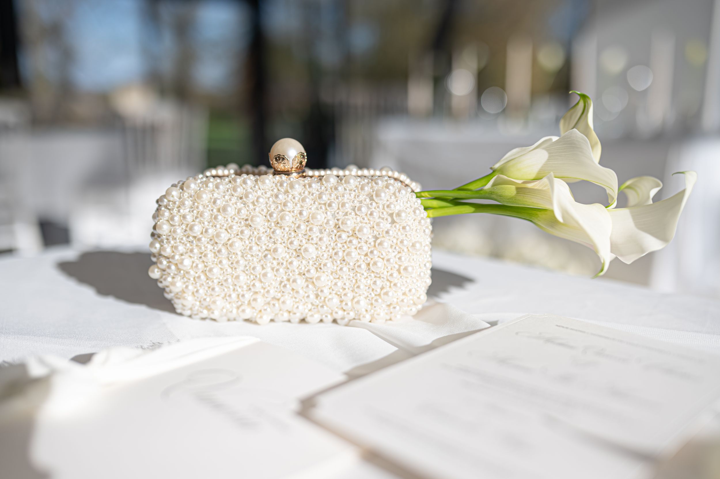 Les éléments de décoration de mariage en perles blanches et les arrangements floraux créent un décor de table élégant lors d'une réception d