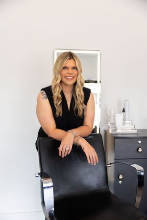 Professional headshots of someone in a black top sitting in an office chair against a white wall.