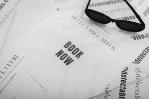 Close-up view of a pair of black framed eyeglasses resting on white documents with printed text.
