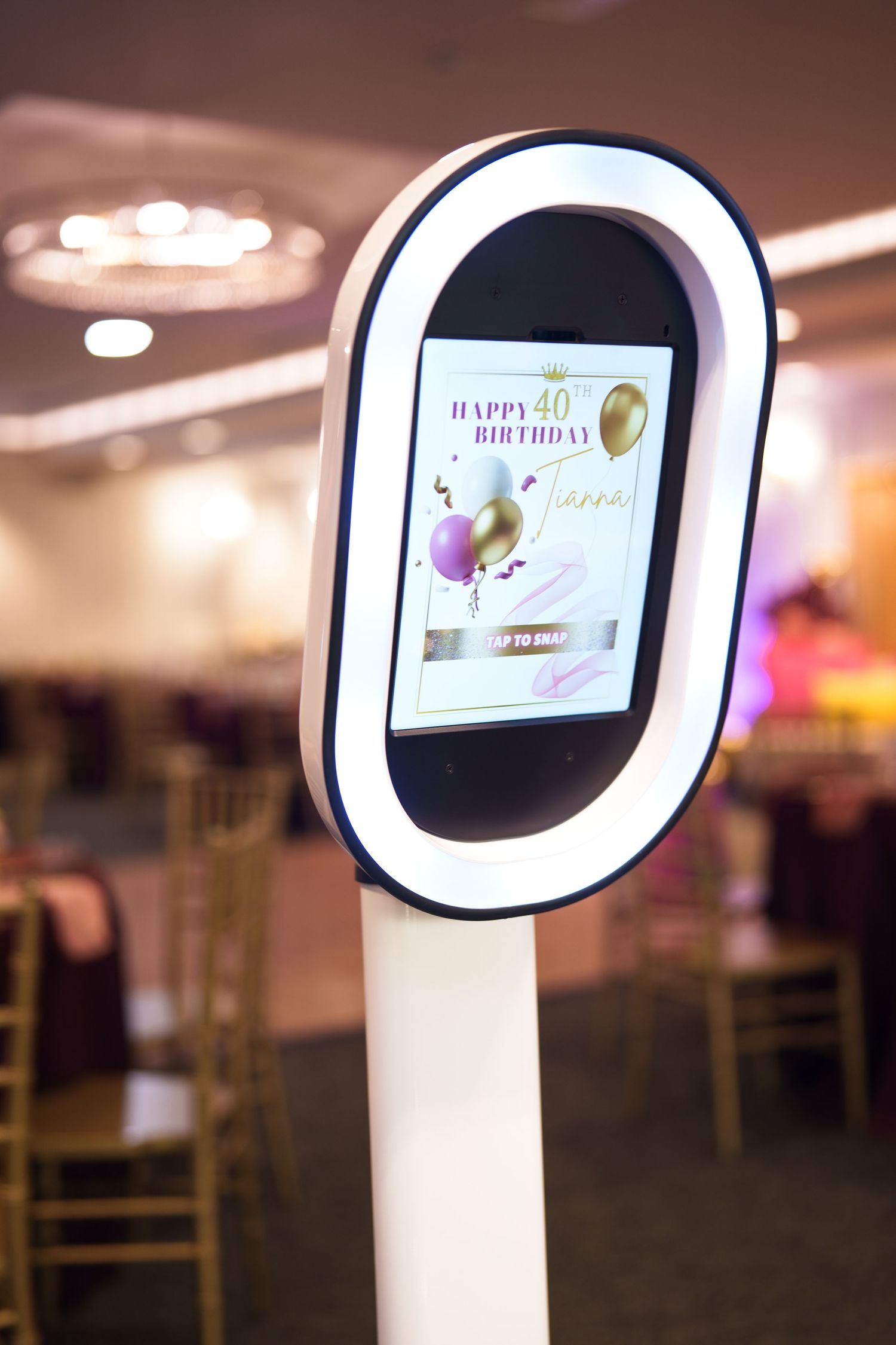 Digital photo booth display with illuminated frame showing interactive interface.