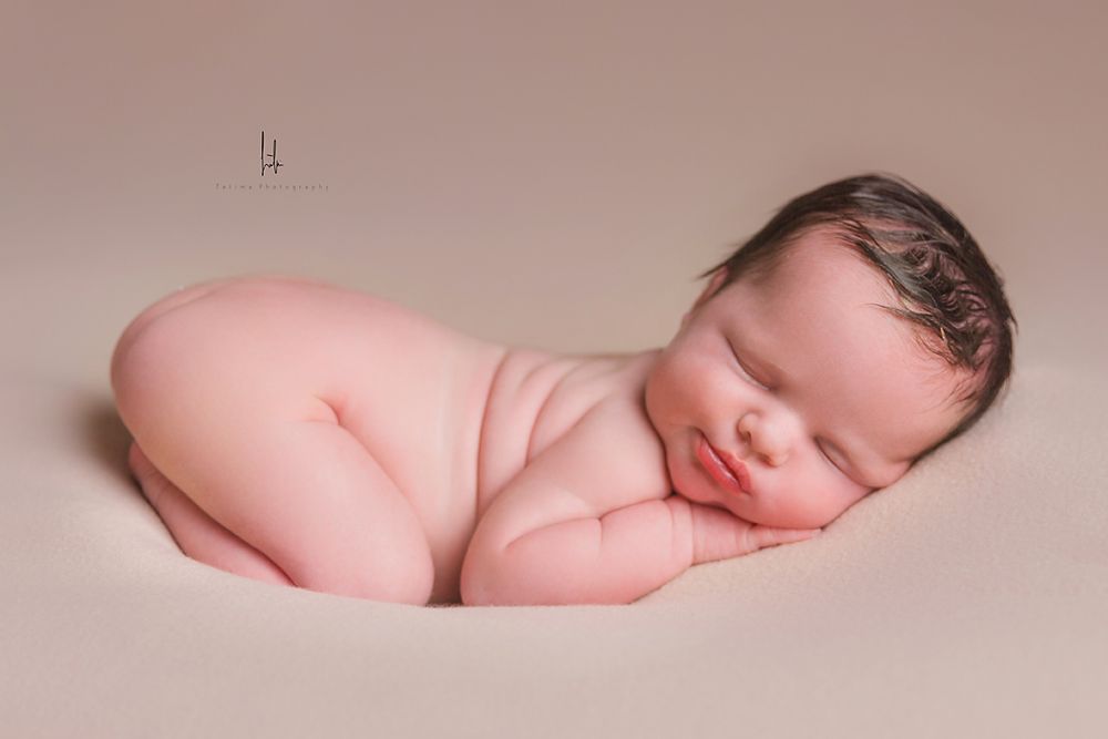 A collection of artistic newborn baby portraits showing peaceful sleeping poses on soft pink backgrounds.
