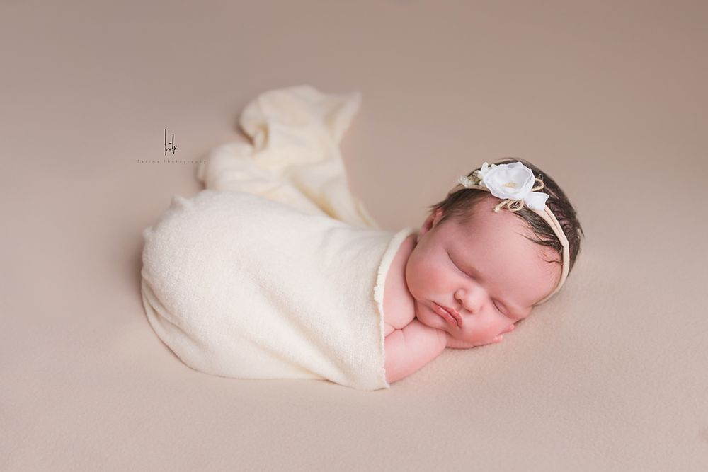 Sleeping newborn wrapped in soft white fabric lying in different peaceful poses on beige background.