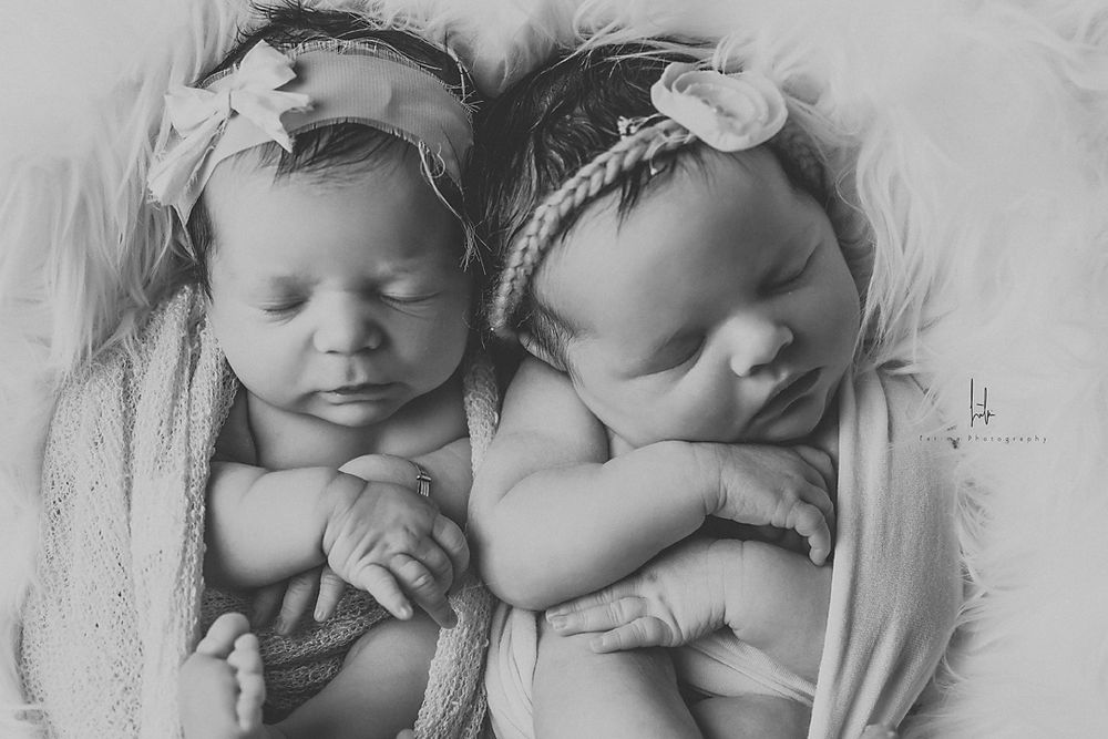 A black and white collage of sleeping newborn babies in various poses and positions.