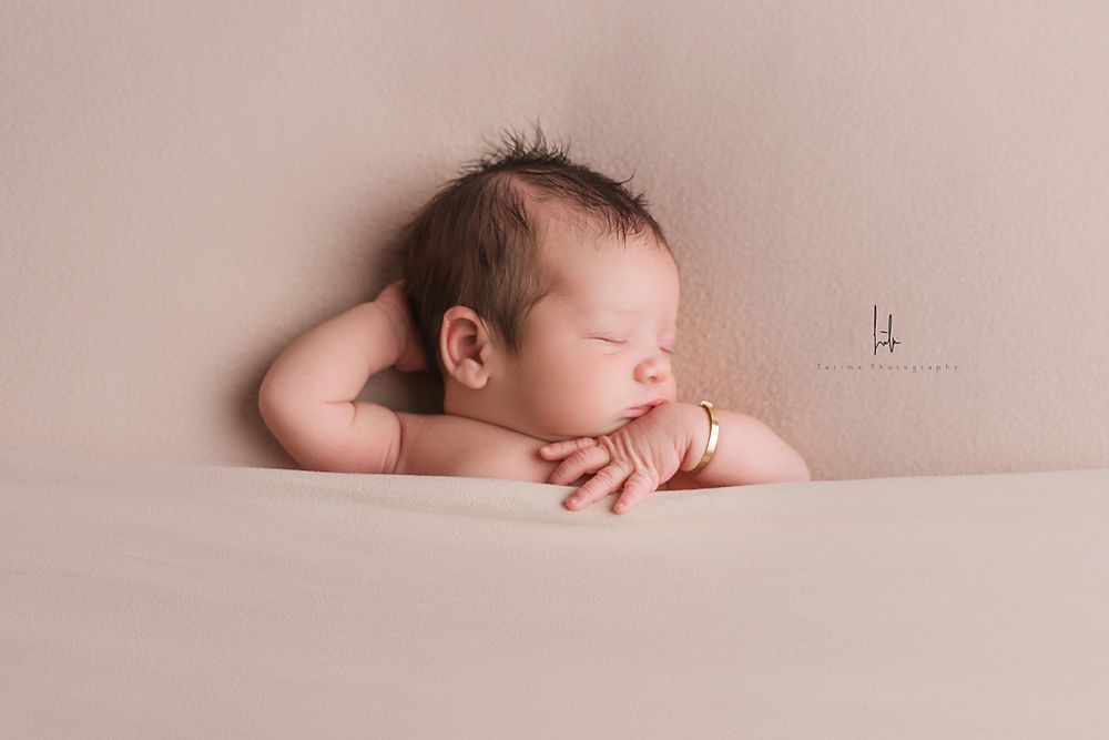 Series of minimalist newborn photography portraits with babies sleeping on neutral beige backgrounds.