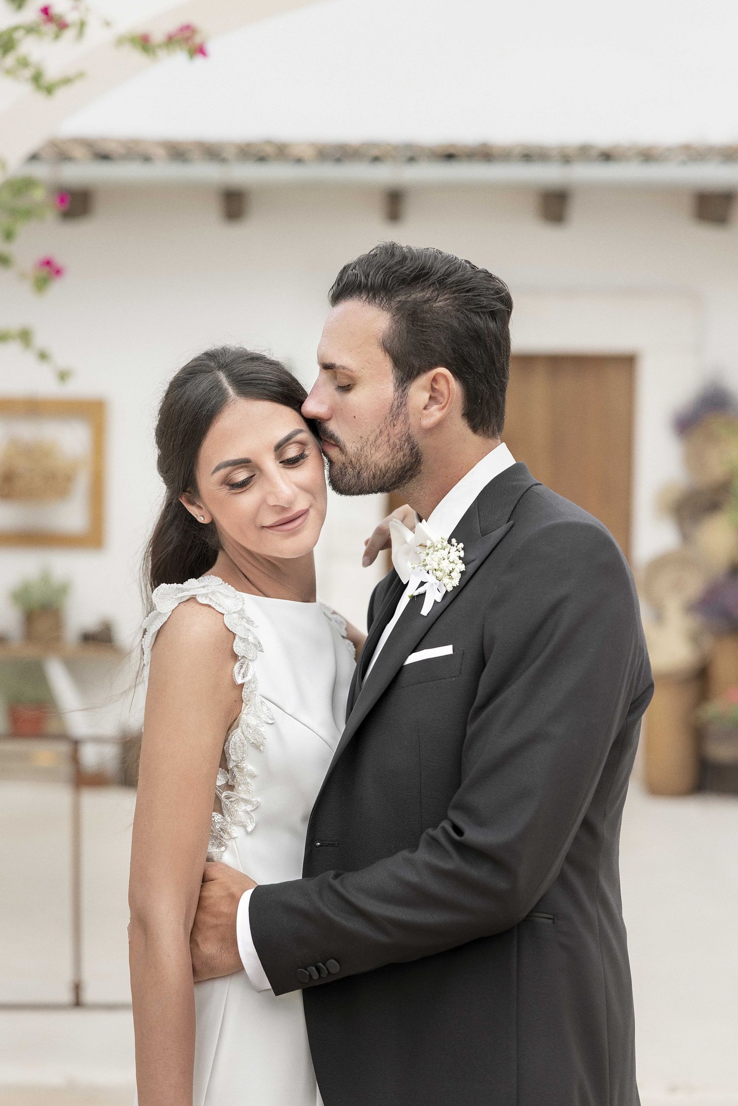 A romantic moment between newlyweds sharing tender embraces during their wedding photoshoot.