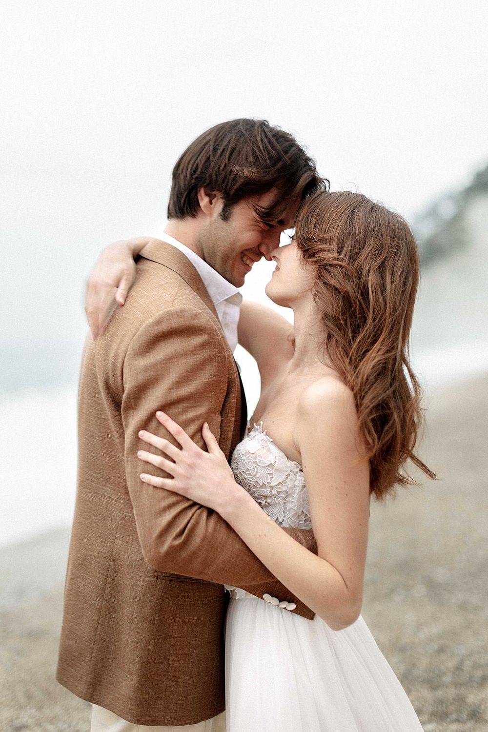 A romantic sequence of wedding photos shows a couple in brown suit and white dress sharing tender kisses on a beach.