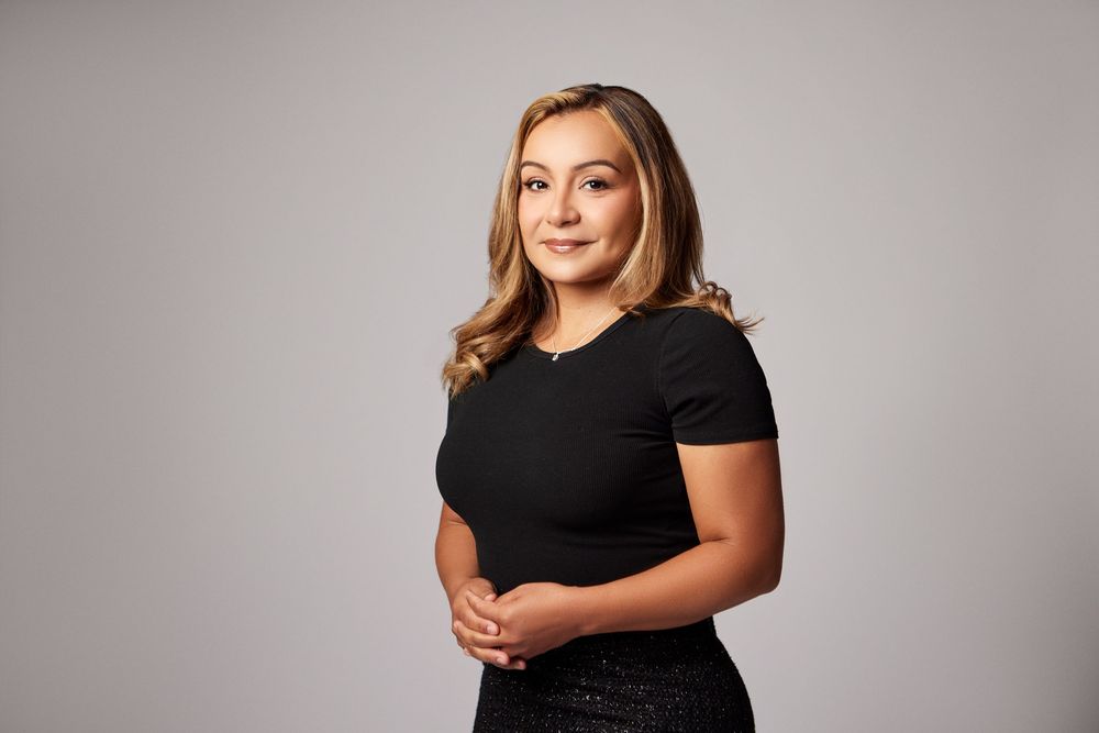 Professional studio portraits in black dress showing confident poses.
