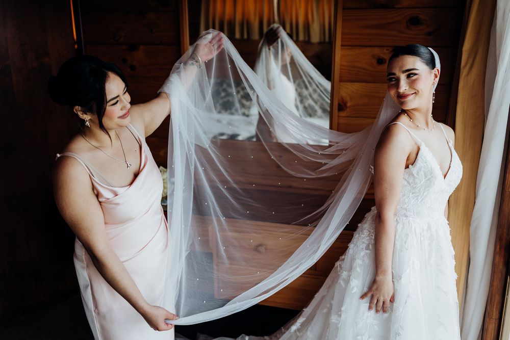 Elegant bridal preparations featuring flowing white veils and delicate details in a warmly lit indoor setting.