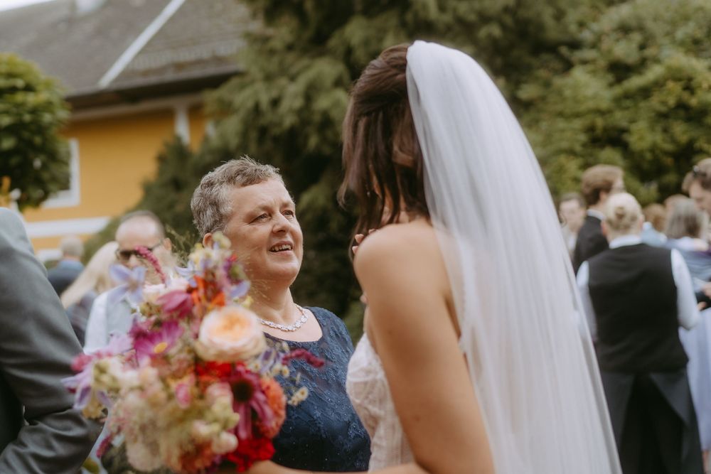 Wedding guests celebrating with confetti and laughter during an outdoor reception.