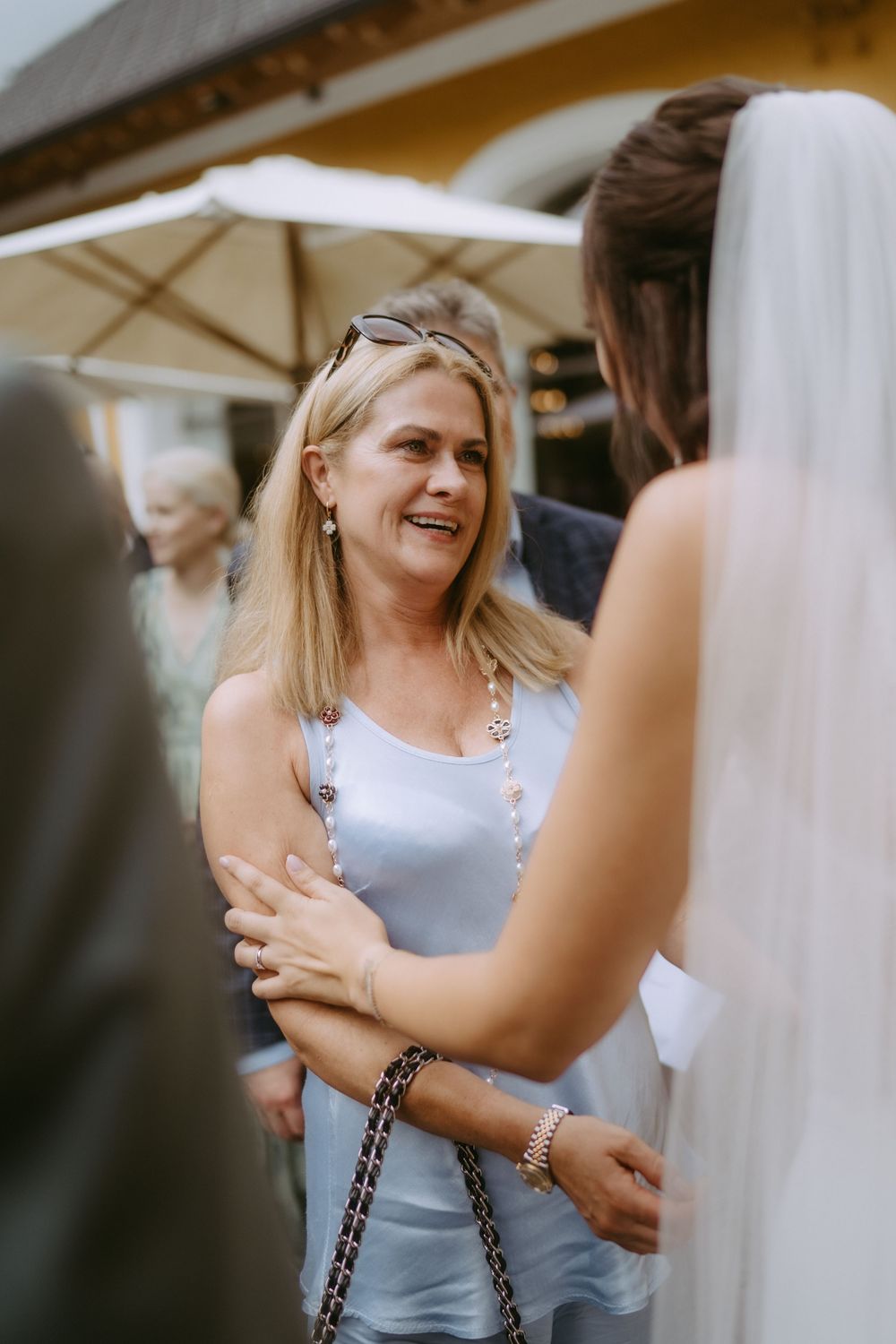 Guest in light blue dress sharing warm embraces at wedding celebration.