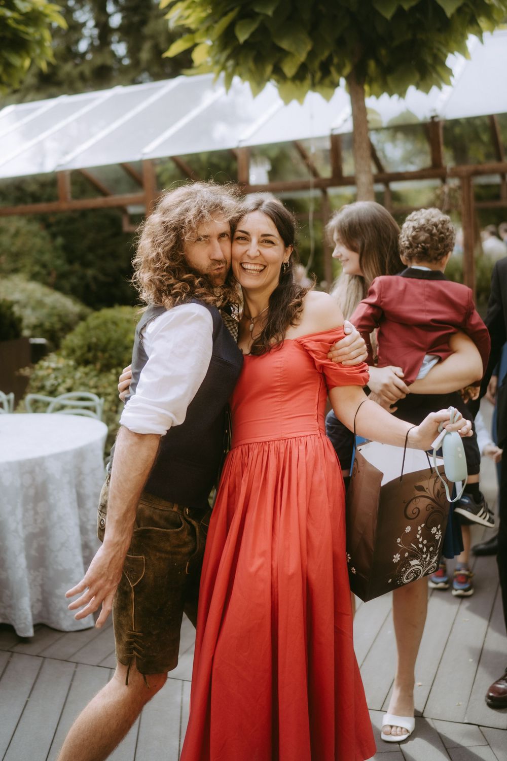 Wedding guests in traditional German attire celebrating at an outdoor reception.