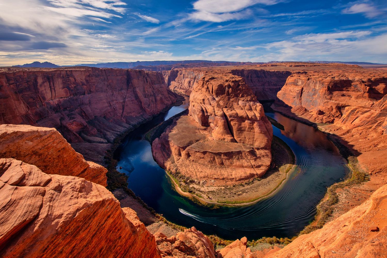 Horseshoe Bend on the Colorado River near Page Arizona features dramatic red cliffs curving around turquoise waters.