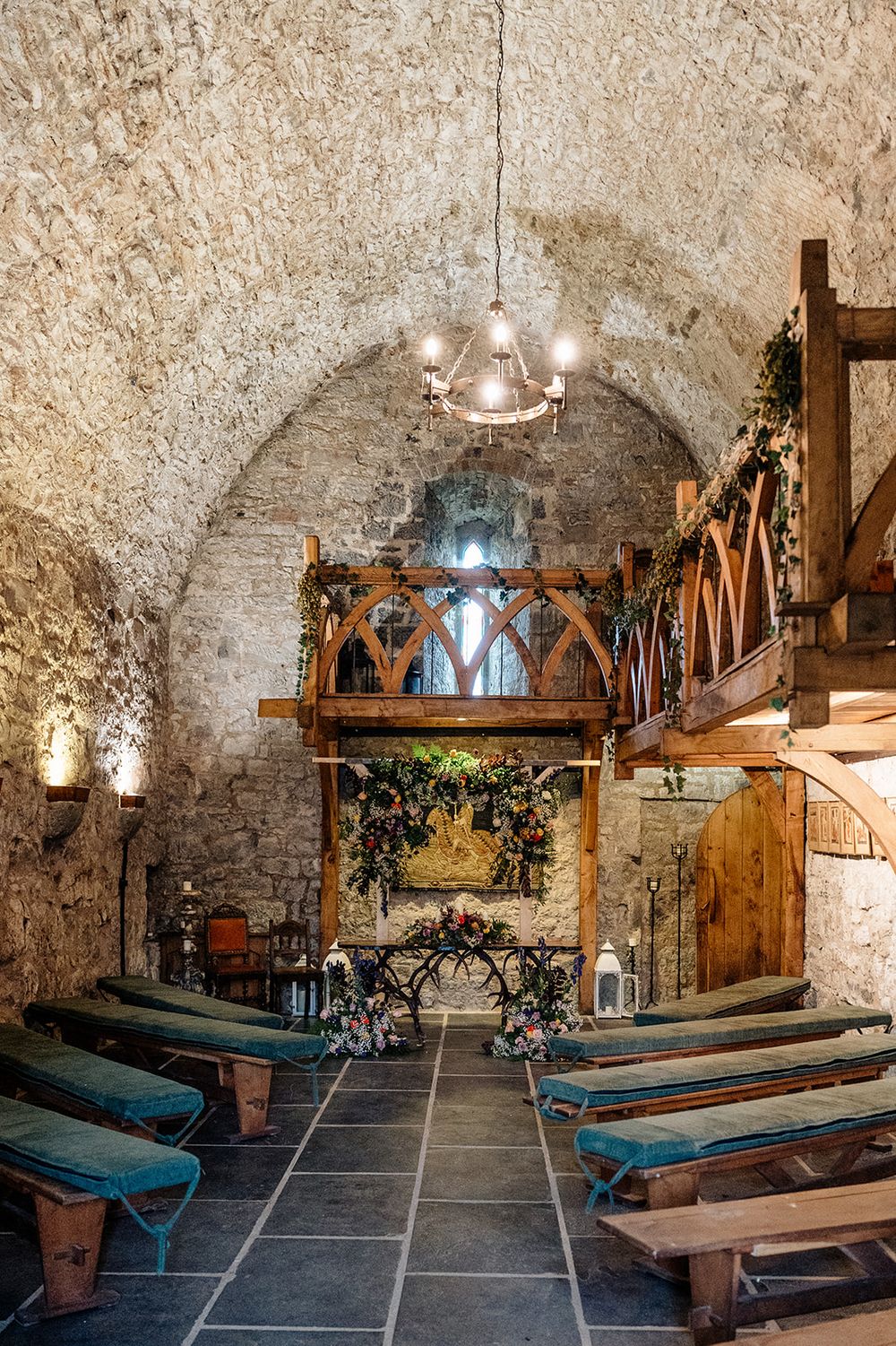 Medieval stone cellar with wooden benches, rustic decor, and arched ceiling showcases historic dining atmosphere.