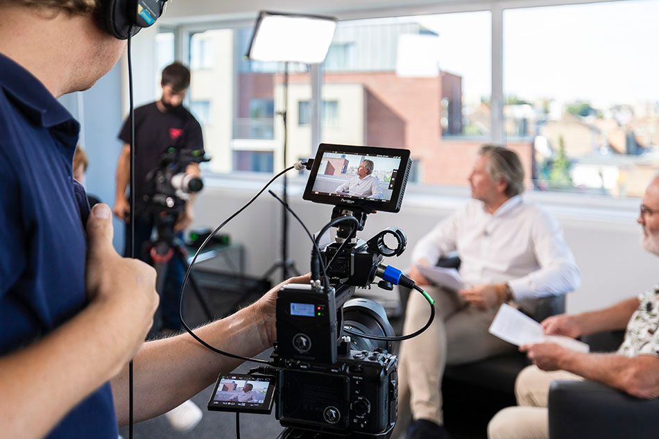 Behind-the-scenes video production setup with cameras and lighting equipment.