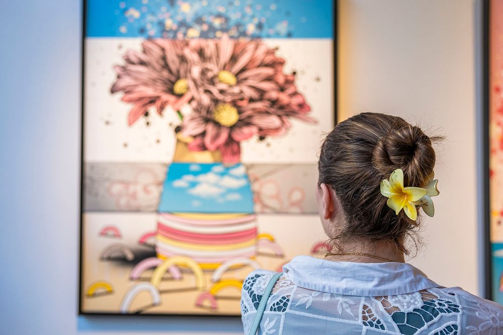 Colorful children's artwork displayed on wall in series of framed pieces.