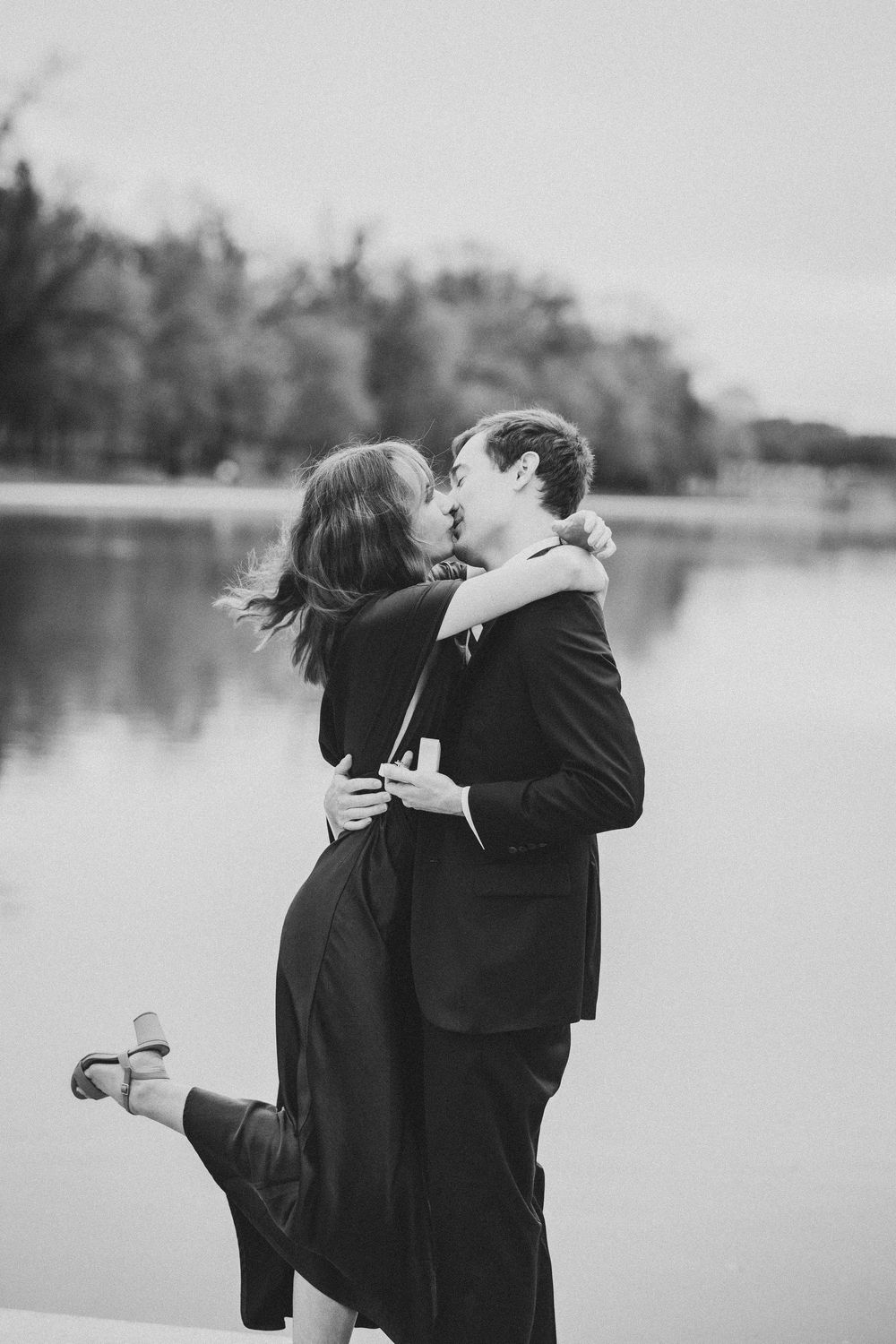 A romantic black and white photo series showing a couple embracing by the reflecting pool in DC