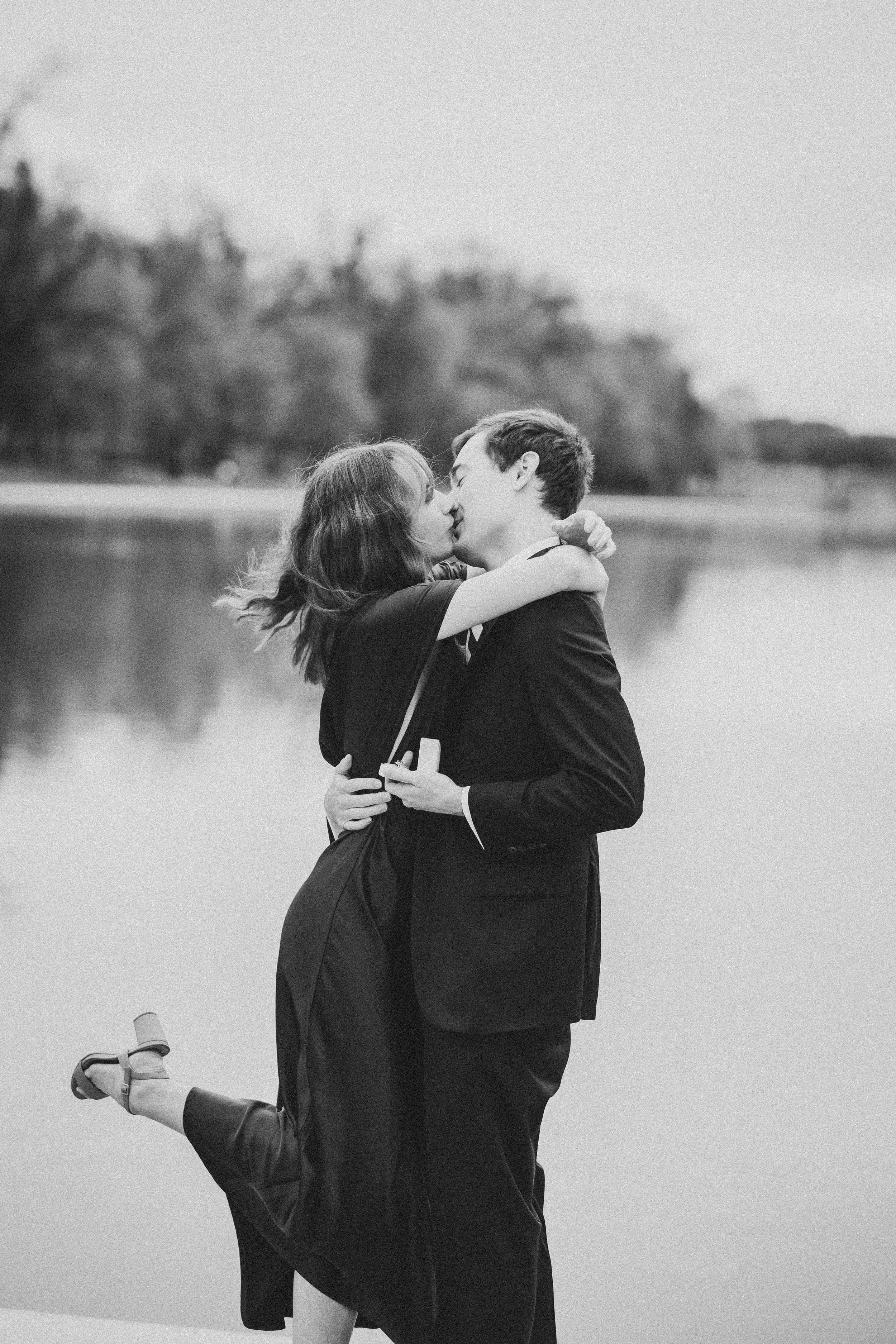 A romantic black and white photo series showing a couple embracing by the reflecting pool in DC