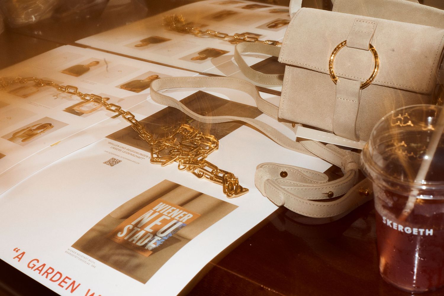 Gold chain jewelry and beige handbag displayed on Skergeth garden catalog pages.