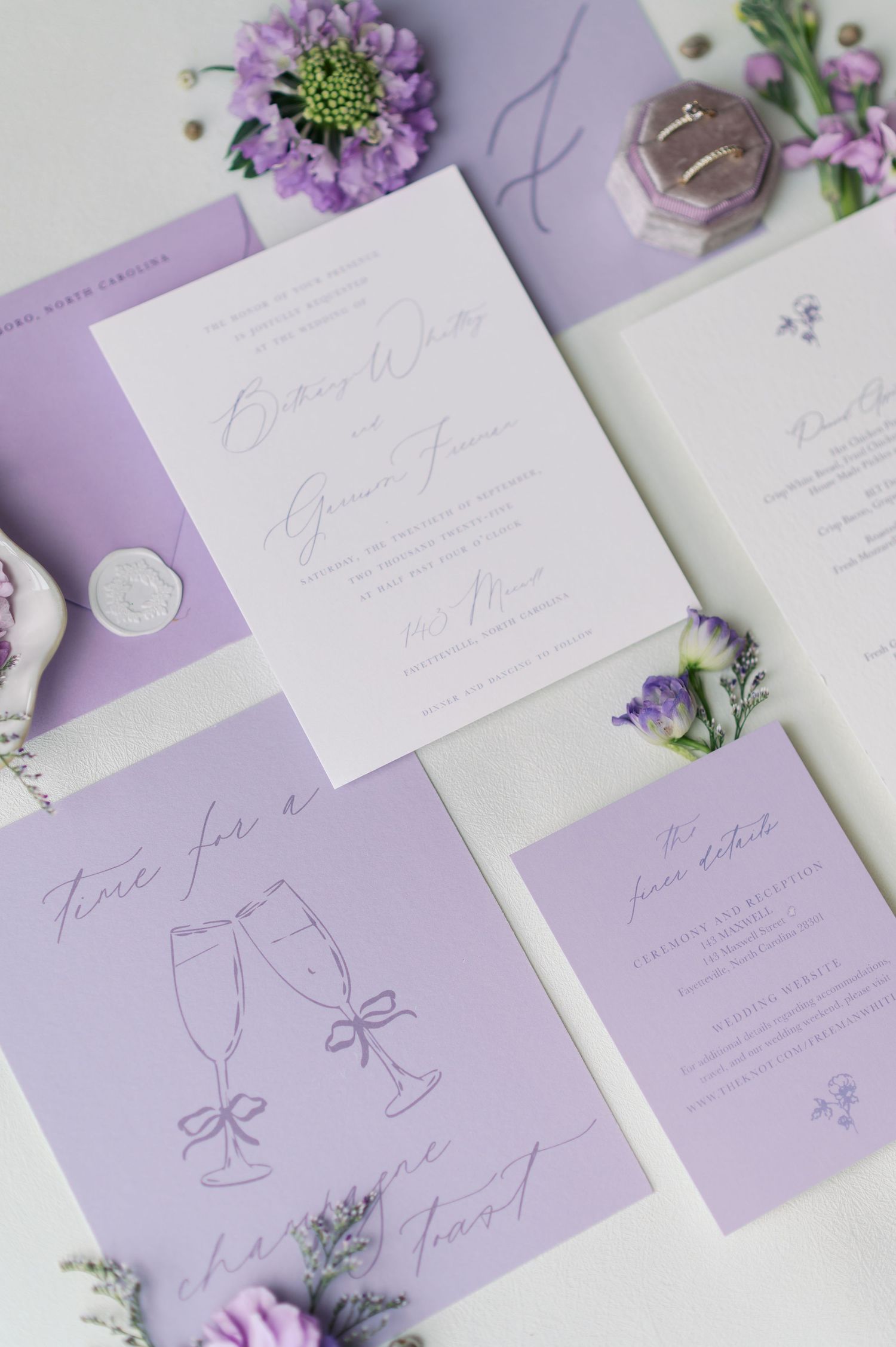 Elegant wedding stationery suite in lavender and white with floral accents and calligraphy on purple background.