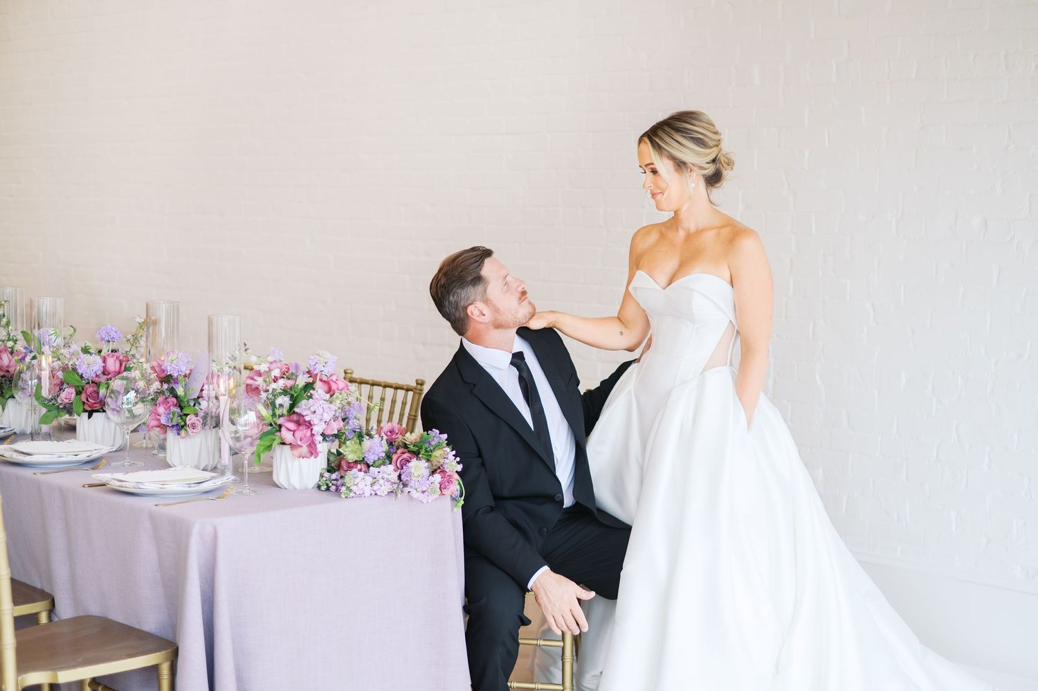 A romantic wedding reception venue with pink and purple floral centerpieces and elegant table settings photo by fayetteville NC photographer