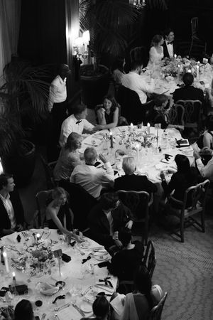 Black and white photo showing guests seated at elegant dining tables during a formal event.