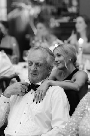 Wedding reception guests in formal attire seated at tables during an evening celebration.