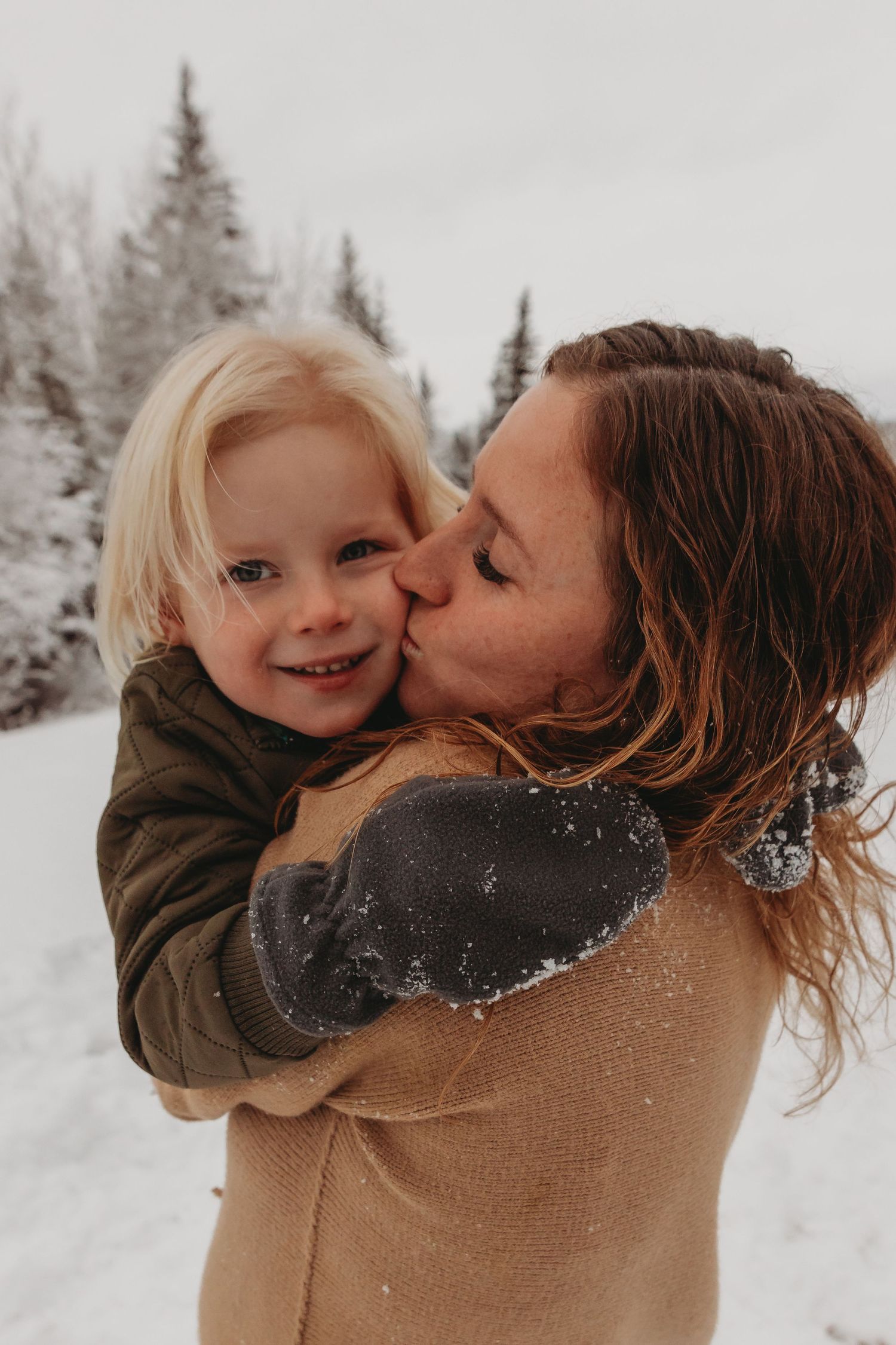 A tender moment shared between parent and child in a snowy winter setting.
