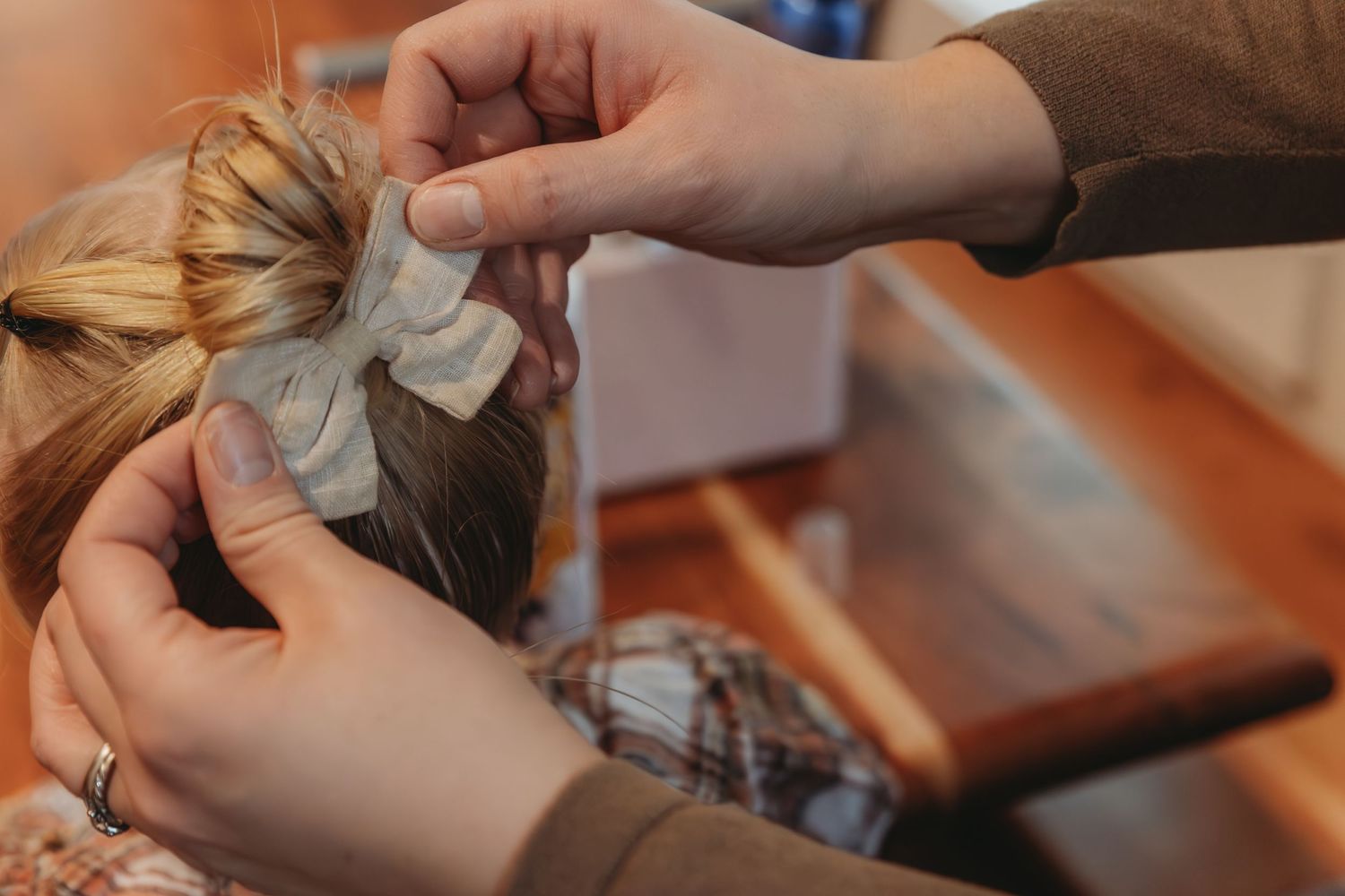 Hands styling and arranging hair with decorative accessories.