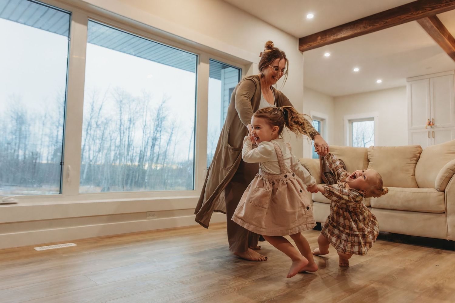 Dancing together in cozy living room with winter landscape visible through windows.