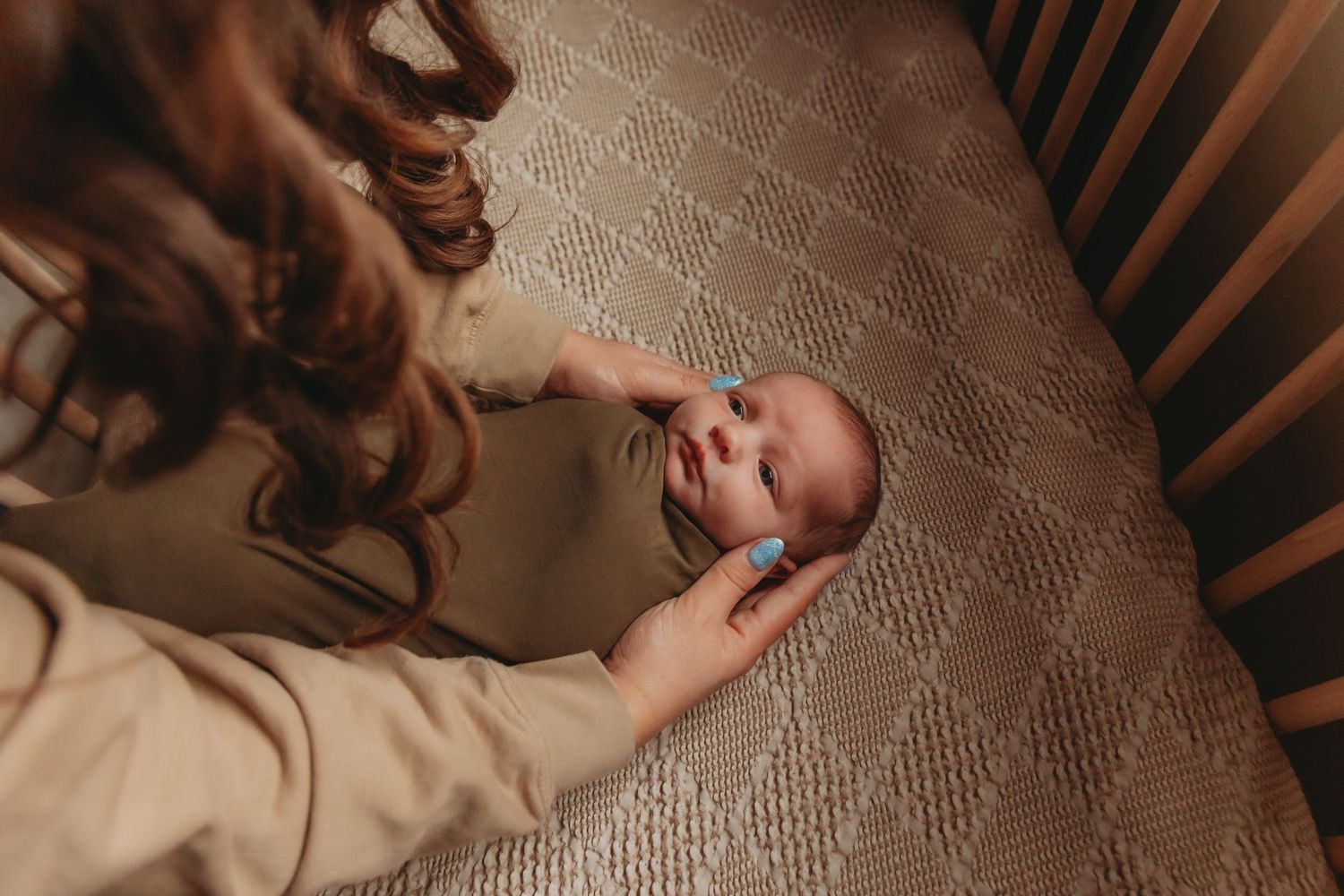 Overhead view of gentle interaction with baby in peaceful indoor setting.