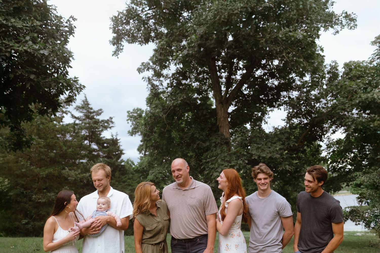 A panoramic sequence of candid family moments captured in a series of photos outdoors against green trees.