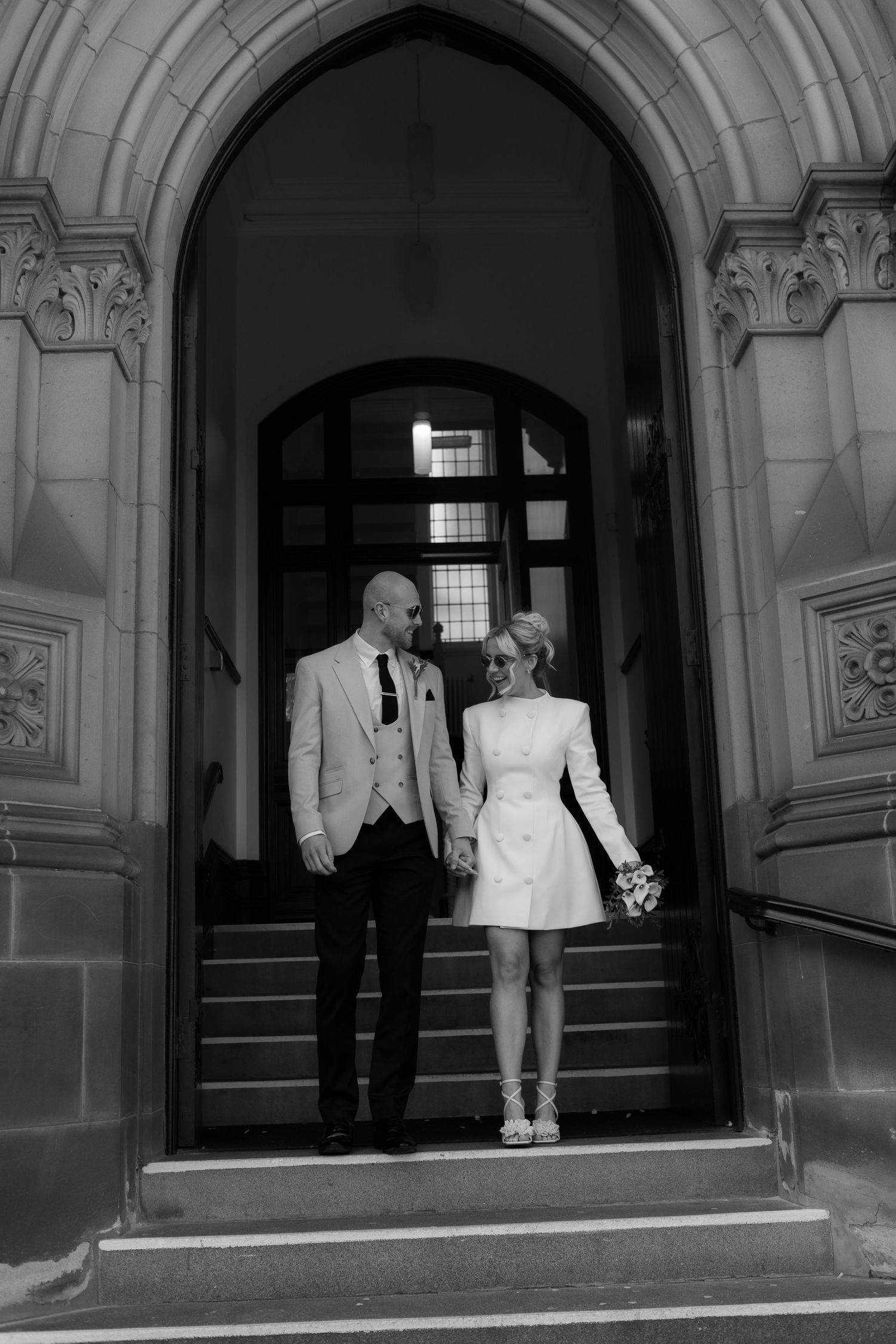 bride and groom walking down the stairs after their ceremony at middblesbrough registry office